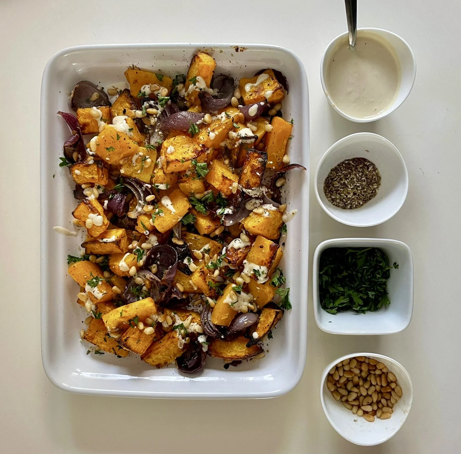 Courge rôtie au tahini, persil et pignons